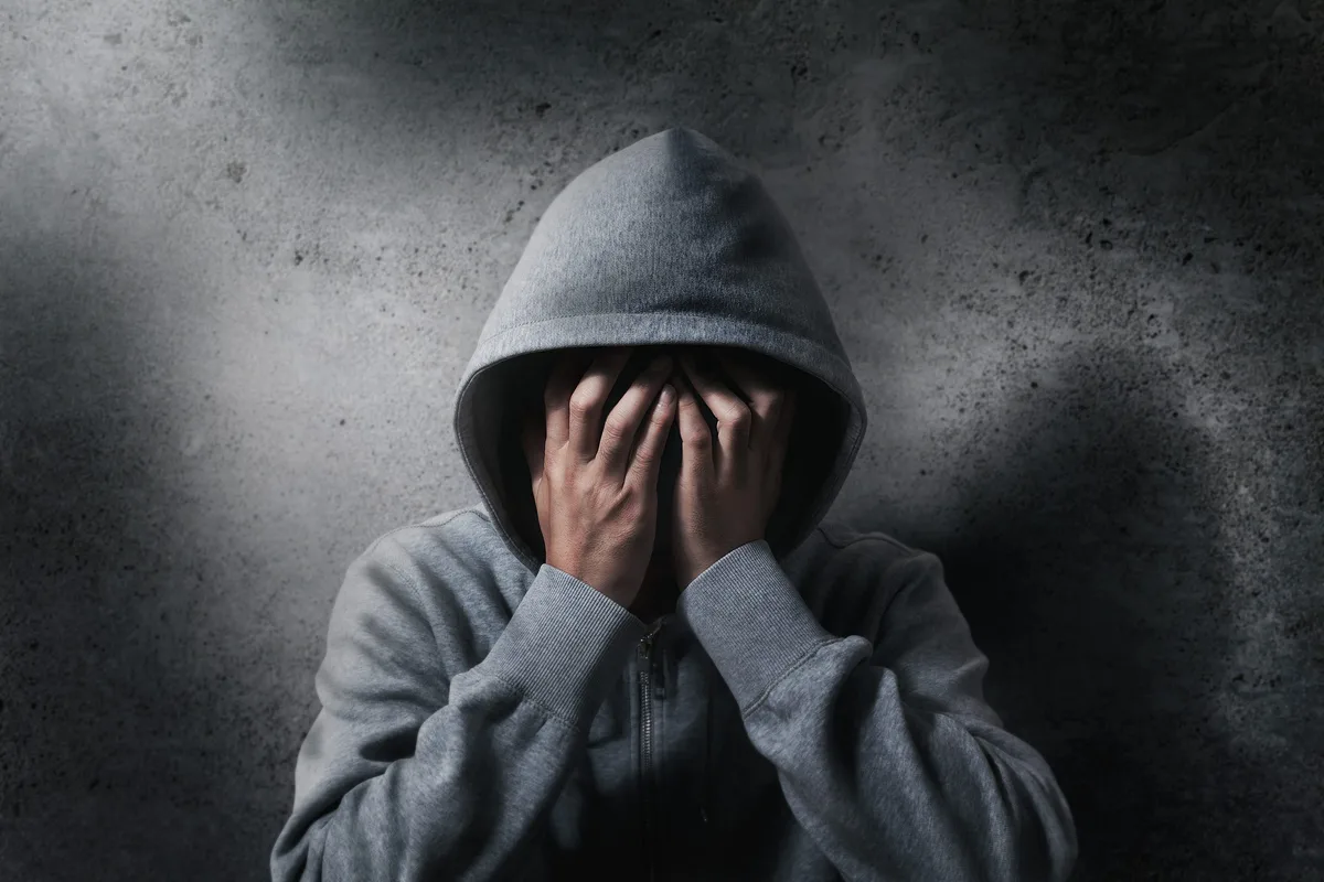 hopeless drug addict going through addiction crisis, portrait of young adult man is covering his face as wearing hood after abusing medicine and drug Häufig sieht man vor Gericht, wie das Leben junger Menschen Stück für Stück aus den Fugen gerät. Im Falle des 21-jährigen Steinheimers hat das mit seiner immensen Drogen- und Alkoholsucht zu tun. Für ihn selbst erscheint die Situation aussichtslos.