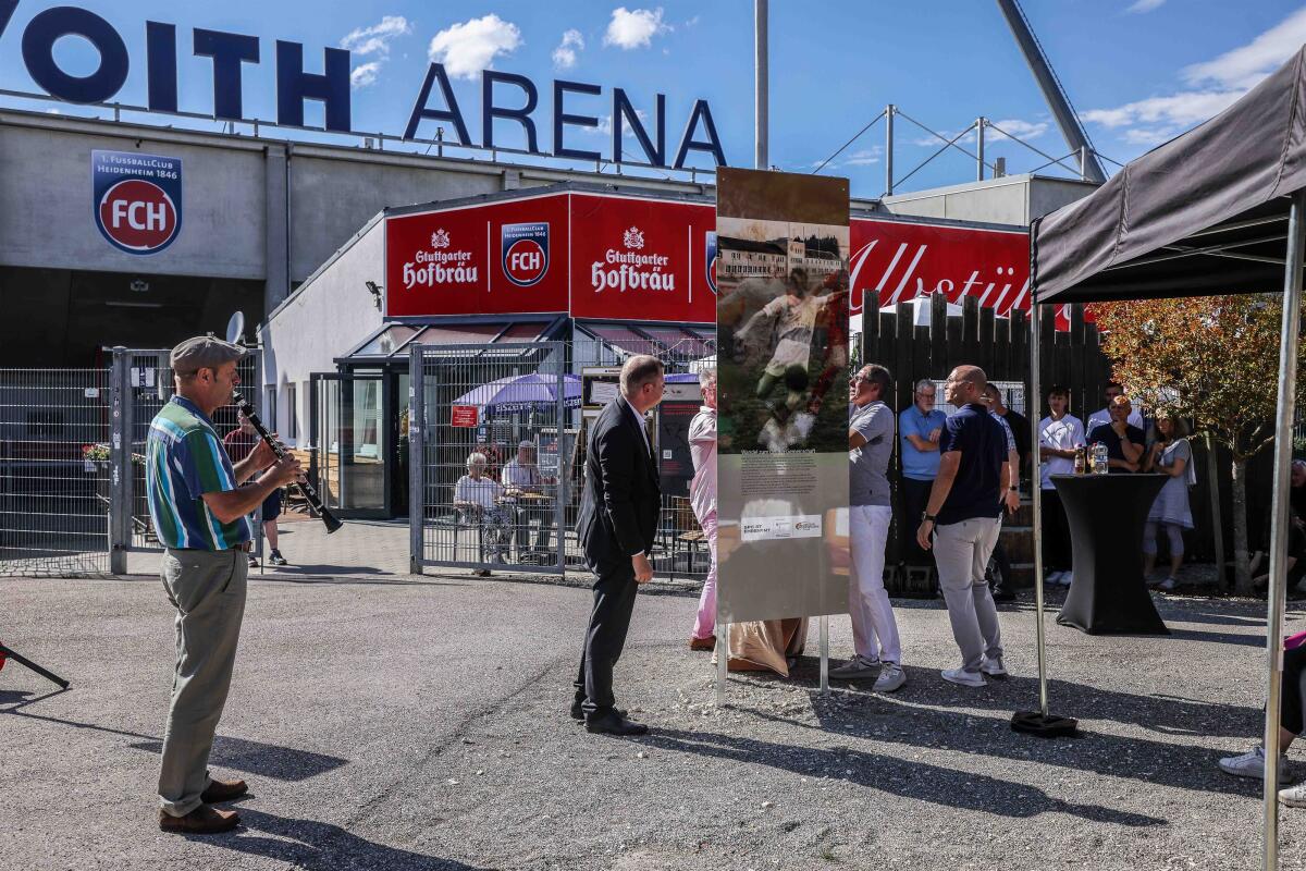 Der Augenblick nach der Enthüllung der Erinnerungsstele vor dem Haupteingang der Voith-Arena auf dem Heidenheimer Schlossberg: Zu sehen ist eine der drei Seiten, hier eine Fotomontage mit Fußball und SA-Sportschule.