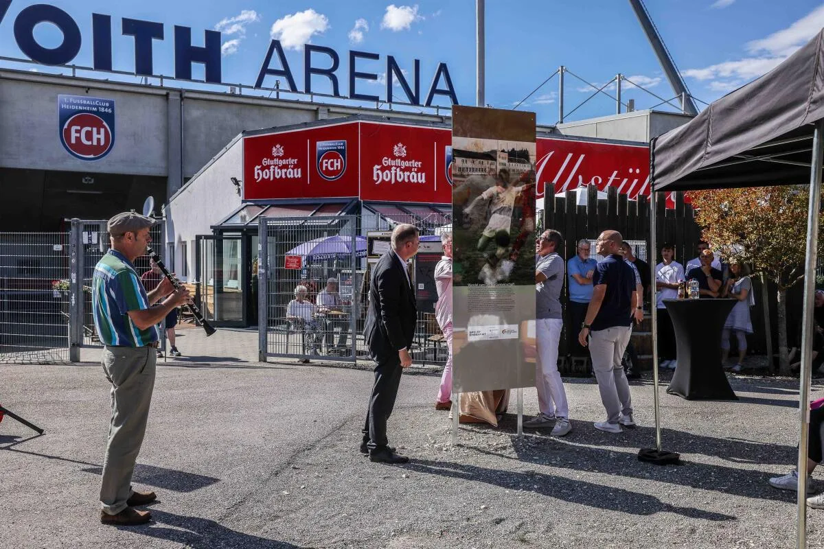Der Augenblick nach der Enthüllung der Erinnerungsstele vor dem Haupteingang der Voith-Arena auf dem Heidenheimer Schlossberg: Zu sehen ist eine der drei Seiten, hier eine Fotomontage mit Fußball und SA-Sportschule.