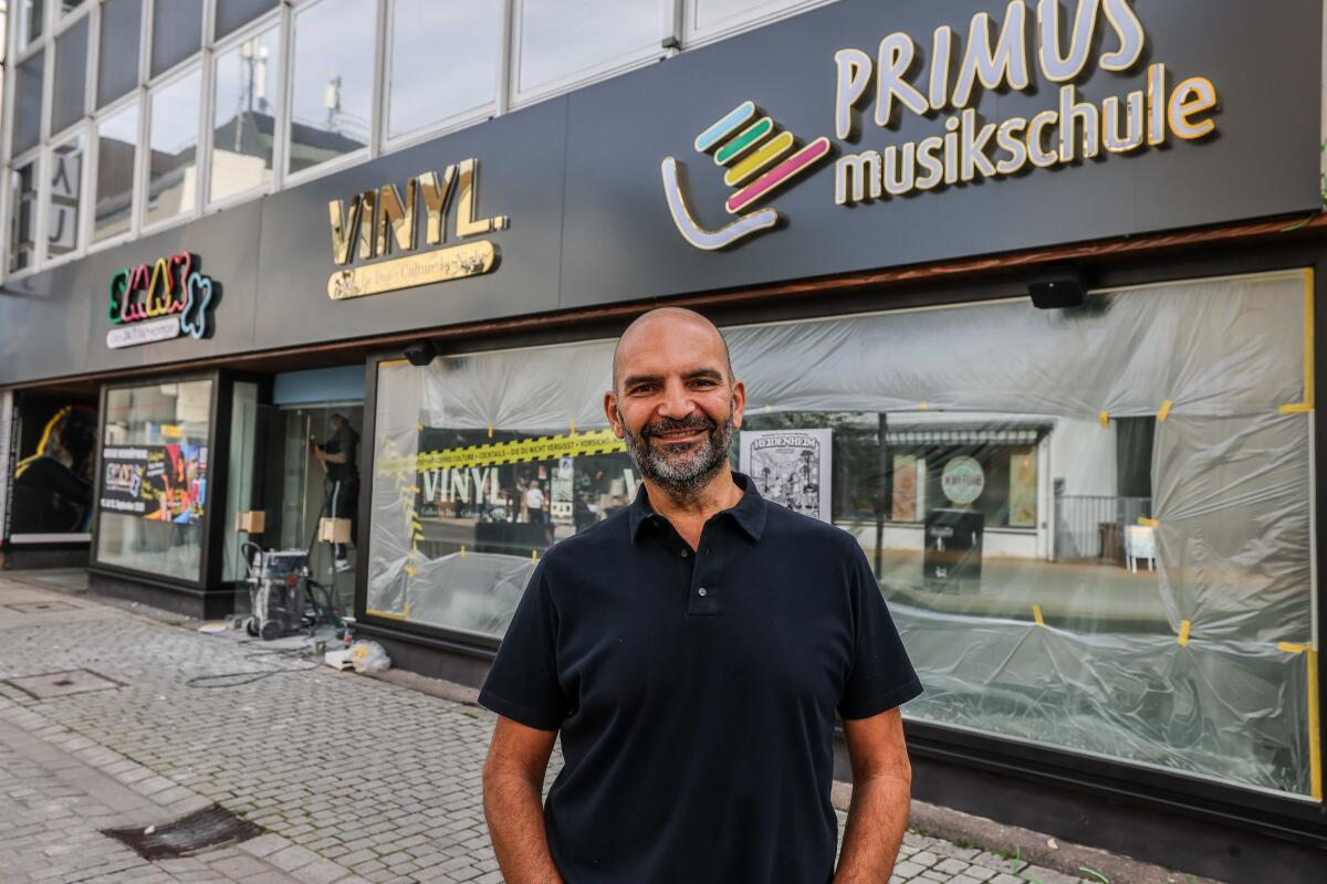 Drei Schriftzüge, eine Idee für die Grabenstraße: Vor der Nummer 5 steht Gianni Pacifico zwischen Musikschule, künftigem „Vinyl“ und dem neuen „Smaxx“. Dass ringsum bald Baustelle ist, schreckt ihn nicht ab.