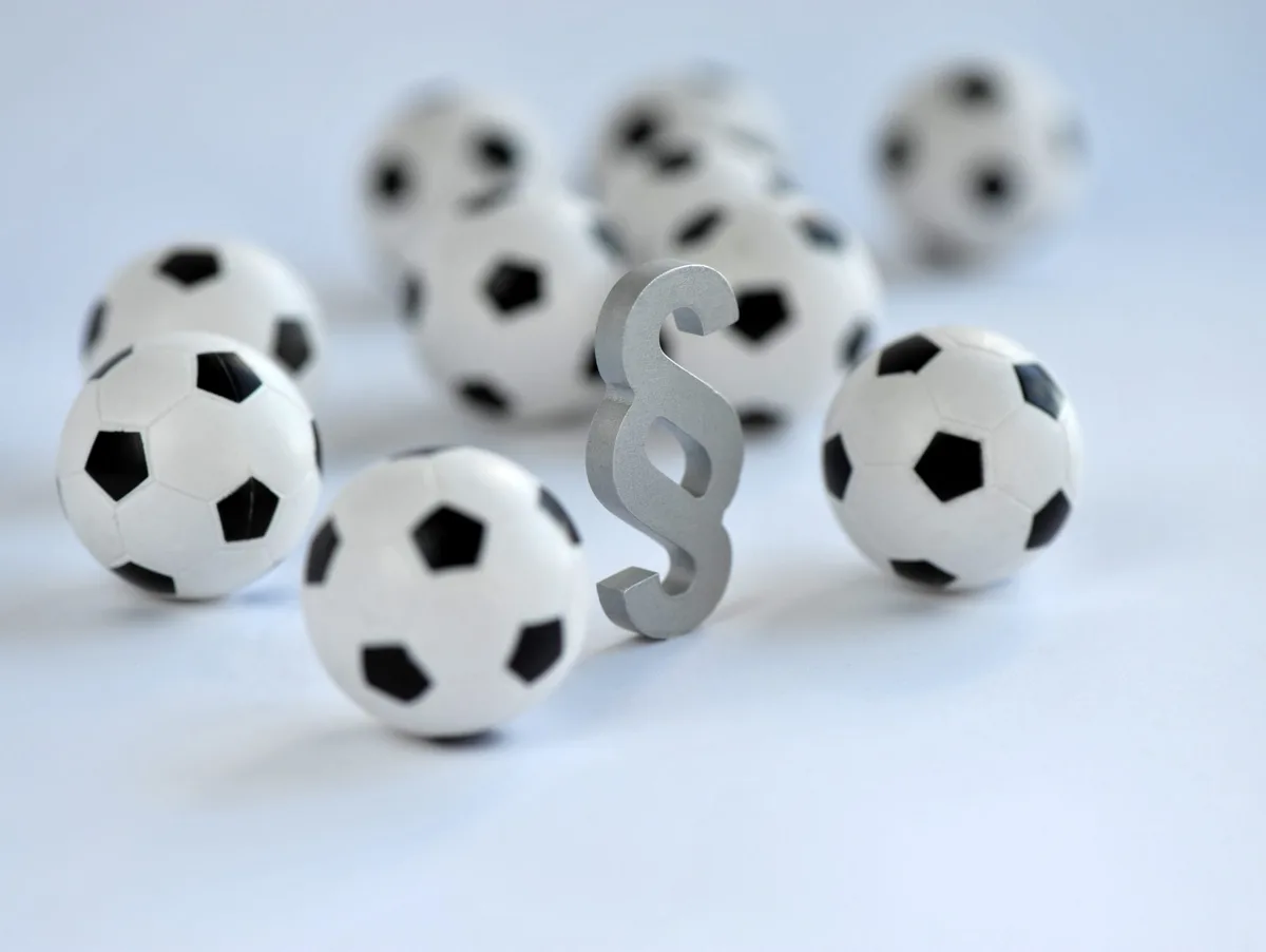 Fußball, Sport, Paragraph, Sportrecht, Fußbälle, Schiedsrichter, Bundesliga, Doping, Vereinsrecht, Gesetz, Übertragungsrechte, symbolisch, Liga, Bundesliga, DFB, Sportverband, Sportgericht Im Fußball müssen immer wieder Sportgerichte tätig werden.