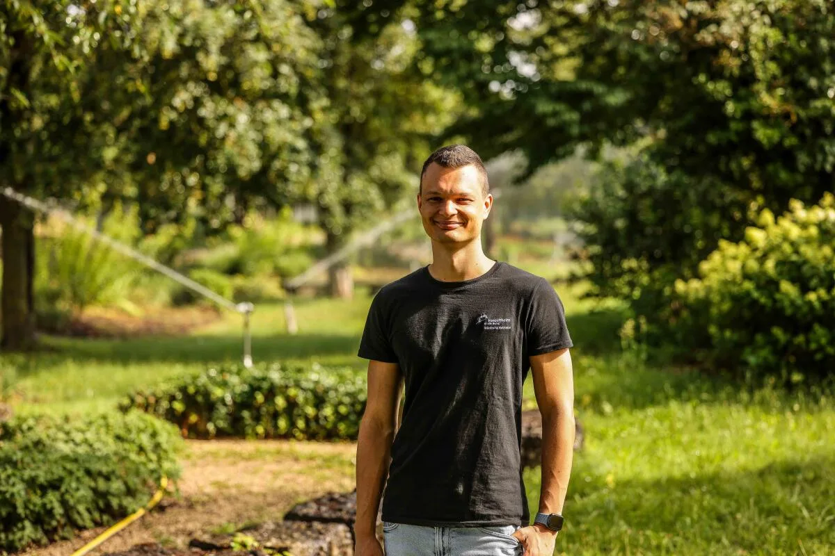 Janik Hafermalz beim Gang durch den Brenzpark, hinter ihm die laufenden Wassersprenkler, ohne die der Park braun statt grün wäre. 