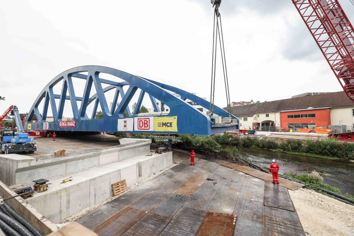 Der Stand der Brückenbaustelle am Mittag des 17. August: Die Brücke ist auf der einen Seite eingehängt am Kran, das andere Ende ruht auf Schwerlastmodulfahrzeugen. 