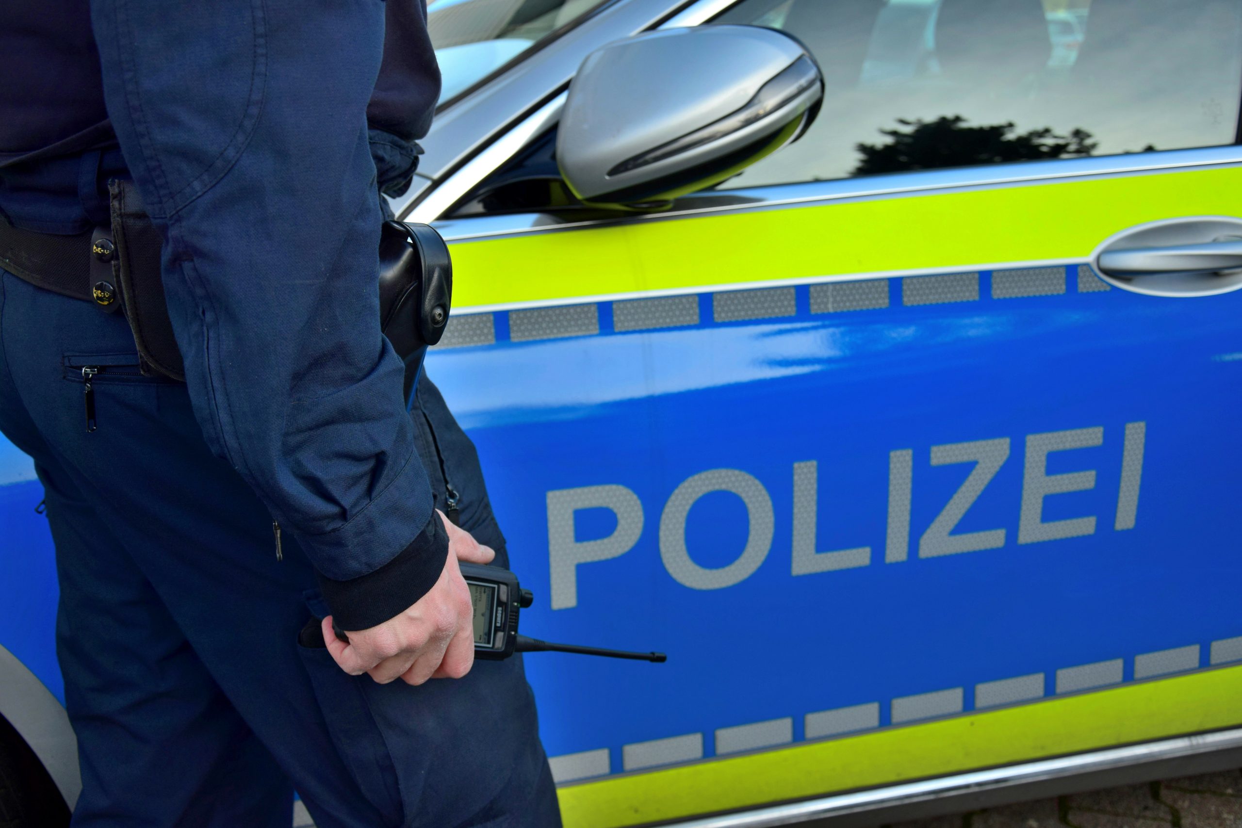 Polizist vor Streifenwagen, Symbolfoto.