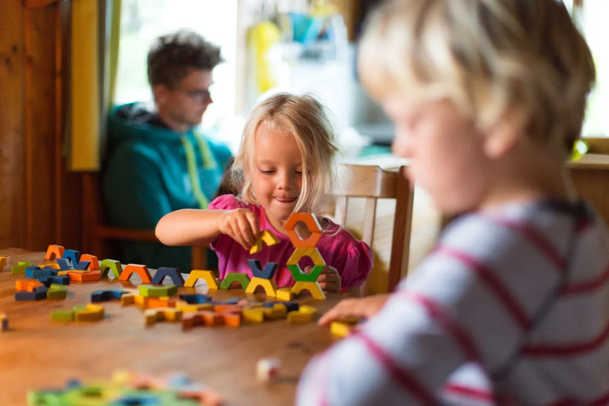 Kinder spielen mit Bauklötzen Die Kosten für die Kindertagespflege sollen ab 2027 steigen.