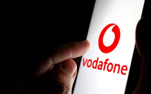 Vodafone logo on a smartphone screen in a dark room and a finger touching it. Am Donnerstagabend waren 1155 Vodafone-Kunden im Landkreis Heidenheim von einer Störung betroffen.