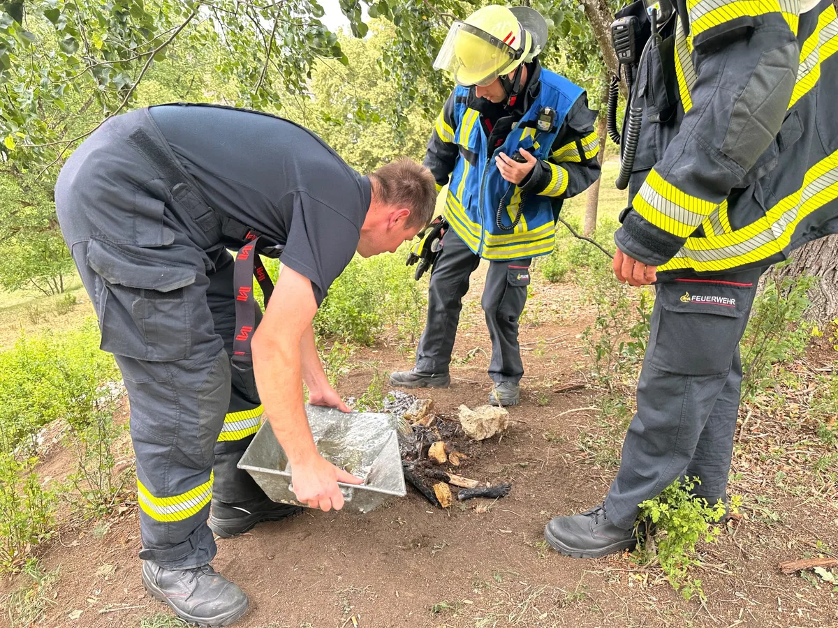 Feuerwehrangehörige sorgten am Dienstag dafür, dass ein Lagerfeuer nicht mehr aufflammt.