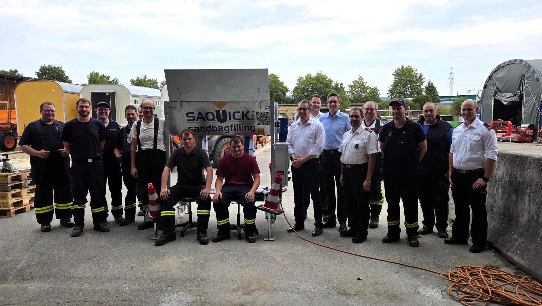 Landrat Peter Polta, Bürgermeister Daniel Vogt, Bauhofleiter Benjamin Schwarz sowie Vertreter der Kreisfeuerwehr, der Feuerwehr Herbrechtingen sowie der Abteilungen Bissingen und Hausen bei der Vorstellung der Sandsack-Füllmaschine.