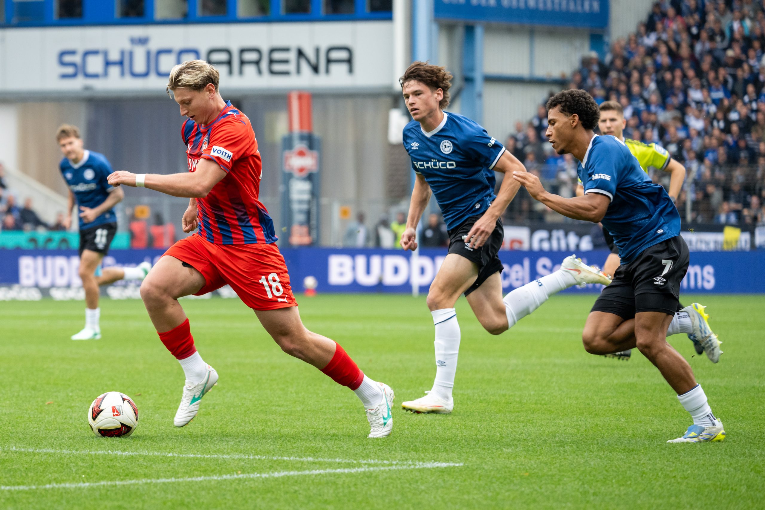 Alessandro Vogt (1. FC Heidenheim 1846, #18) im Laufduell mit Maximilian Grosser (Arminia Bielefeld, #19) und Henri Koudossou (Arminia Bielefeld, #07). DSC Arminia Bielefeld vs. 1. FC Heidenheim 1846 , Fussball, 2. Liga, 06. Spieltag, Saison 2026/2027, 20.09.2026 DFL/DFB Regulations prohibit any use of Photographs as image sequences and/or Quasivideo Foto: Eibner-Pressefoto/Thomas Haesler