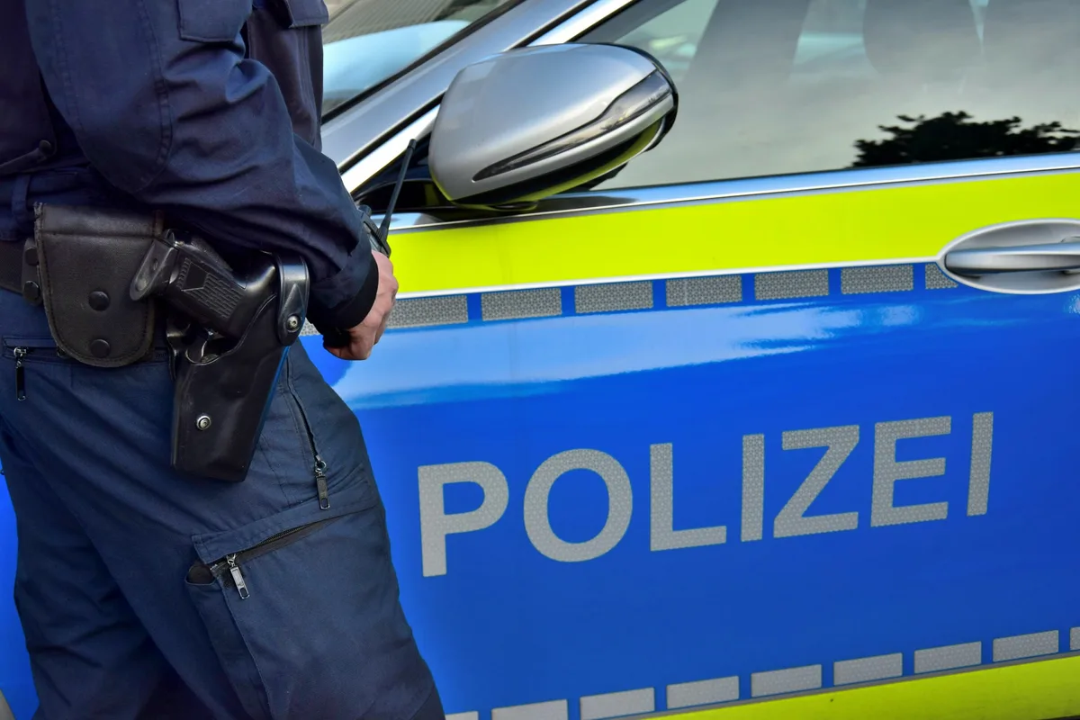 Polizeibeamter vor Streifenwagen, Symbolfoto. Polizeibeamter vor Streifenwagen, Symbolfoto.