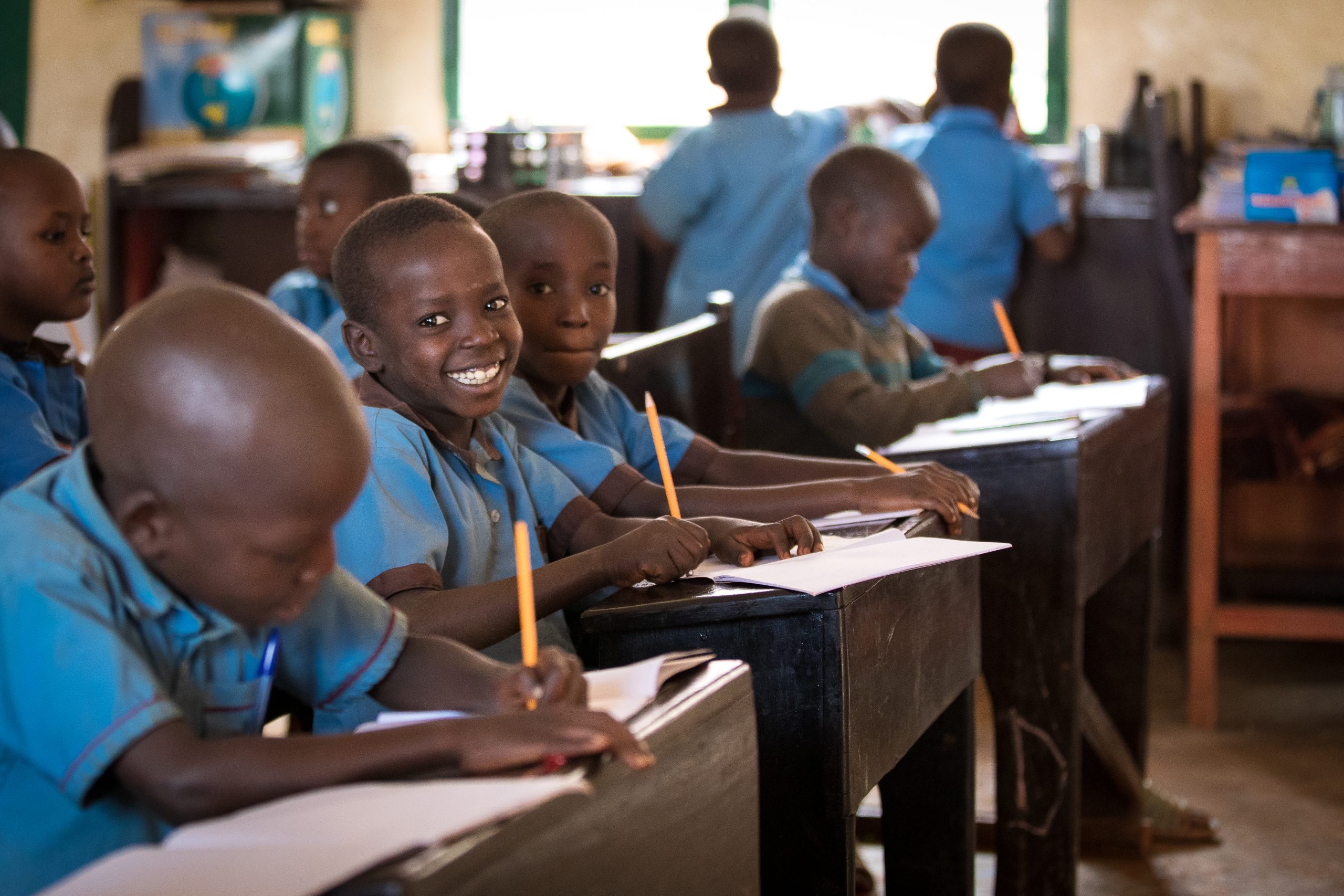 Unterricht in der Karubabi-Schule des Kinderwerkes in Burundi. Zu Schuljahresbeginn bekommt jedes Kind ein Set Schulmaterial mit Stiften und Heften geschenkt. Um Papier zu sparen, werden die Hefte ohne Leerzeile beschrieben.