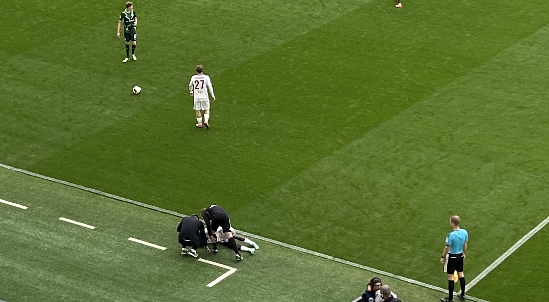 Verletzungspause: Im Spiel des 1. FC Heidenheim beim VfL Wolfsburg blieb Christian Conteh auf dem Rasen liegen. Wolfsburgs Trainer Tobias Strobl (links) und der vierte Offizielle Robert Wessel kamen zu Hilfe.